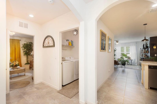 corridor with washer and dryer and light tile patterned floors