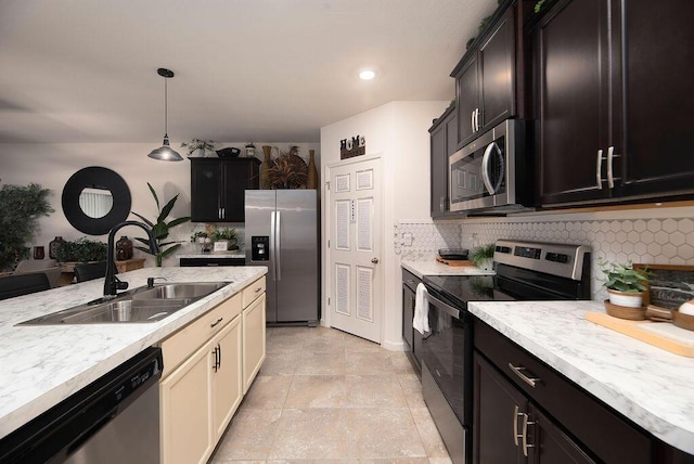 kitchen with appliances with stainless steel finishes, sink, cream cabinets, and decorative backsplash