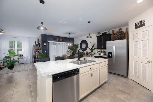 kitchen featuring sink, a center island with sink, pendant lighting, stainless steel appliances, and white cabinets