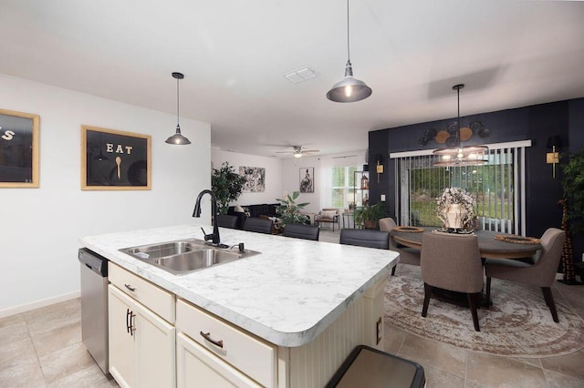 kitchen with sink, hanging light fixtures, dishwasher, an island with sink, and ceiling fan with notable chandelier