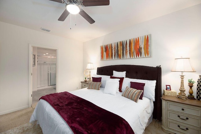 bedroom with connected bathroom, light colored carpet, and ceiling fan