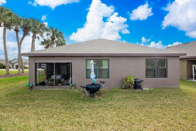 rear view of property featuring a lawn