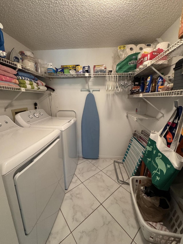 clothes washing area featuring washer and clothes dryer and a textured ceiling