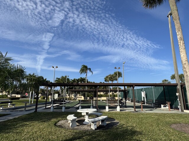 view of home's community with a water view and a lawn