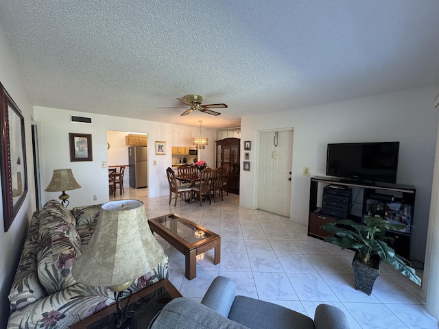 living room featuring ceiling fan and a textured ceiling