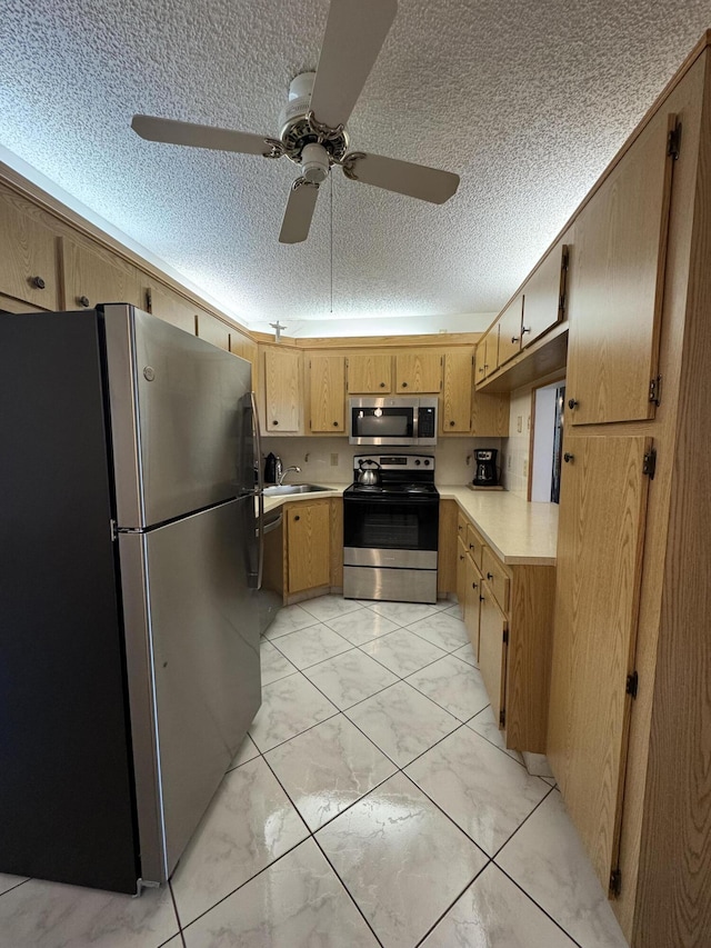 kitchen featuring sink, stainless steel appliances, and a textured ceiling