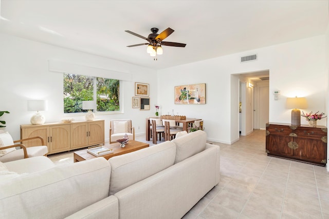 living area featuring ceiling fan, visible vents, baseboards, and light tile patterned flooring