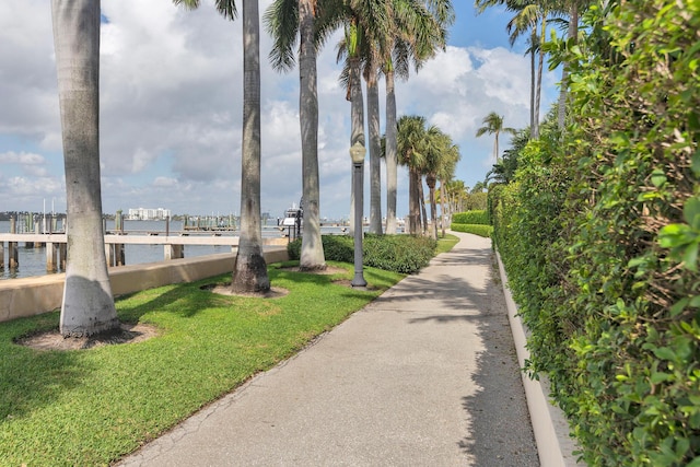 view of home's community with a water view and a lawn