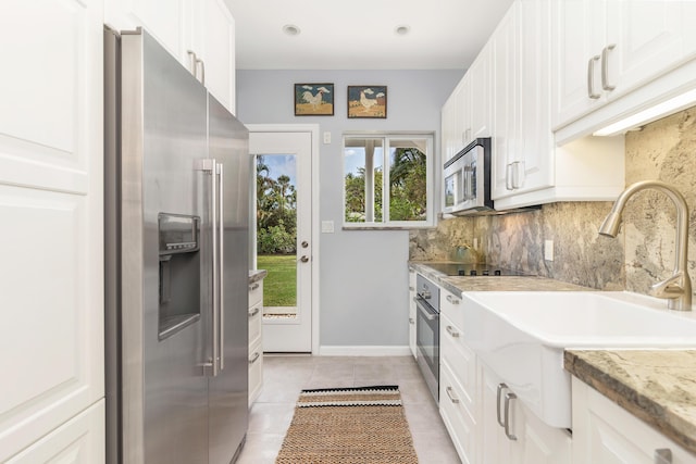 kitchen featuring appliances with stainless steel finishes, sink, decorative backsplash, and white cabinets