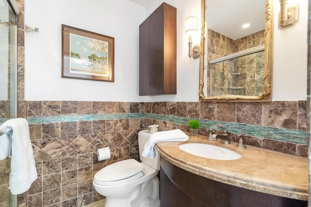 bathroom featuring tile walls, vanity, toilet, and walk in shower