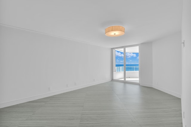 empty room featuring expansive windows and a water view