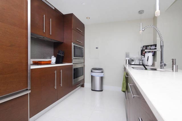 kitchen with pendant lighting, stainless steel oven, sink, and built in microwave