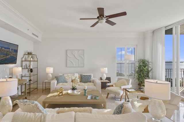 living room with ornamental molding, ceiling fan, and a water view