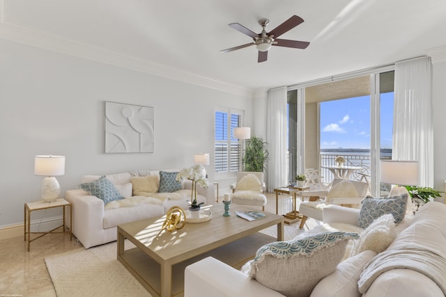 living room featuring expansive windows, ceiling fan, ornamental molding, and a wealth of natural light