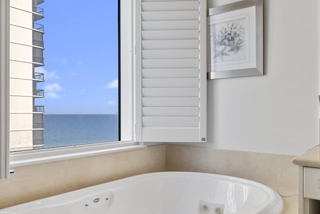 bathroom featuring a water view and a tub to relax in