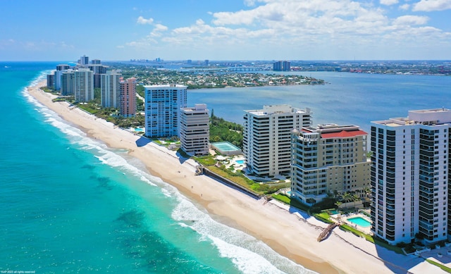 birds eye view of property with a water view and a beach view