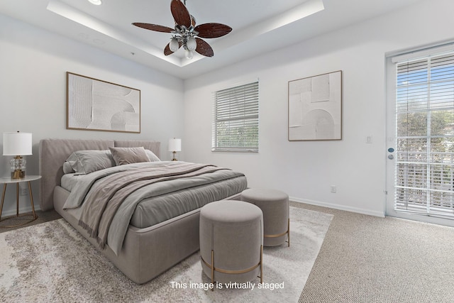 4329 Savannah Bay Pl, Jupiter, FL 33458 - carpeted bedroom with multiple windows, access to exterior, a tray ceiling, and baseboards