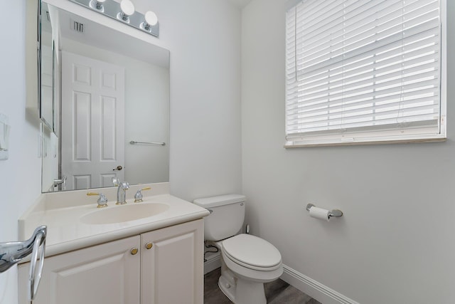 bathroom with vanity, hardwood / wood-style floors, and toilet