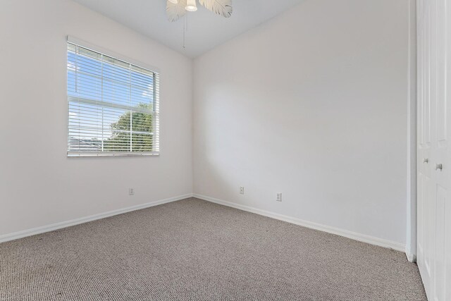 carpeted empty room with ceiling fan and lofted ceiling