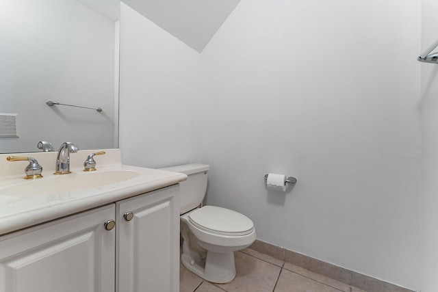 bathroom with lofted ceiling, vanity, toilet, and tile patterned flooring