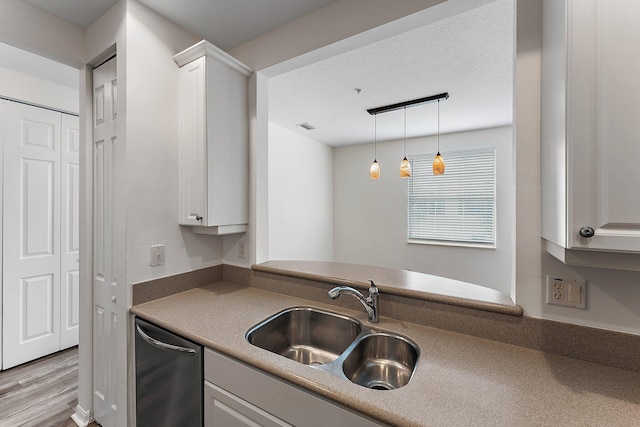 4329 Savannah Bay Pl, Jupiter, FL 33458 - kitchen with dishwasher, a sink, white cabinets, decorative light fixtures, and wood finished floors