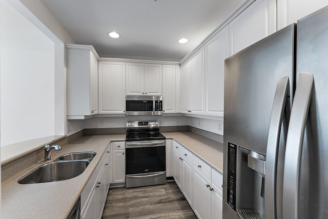 kitchen featuring dark hardwood / wood-style flooring, sink, stainless steel appliances, and white cabinets