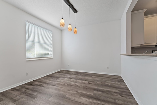 unfurnished dining area featuring dark hardwood / wood-style floors and a textured ceiling