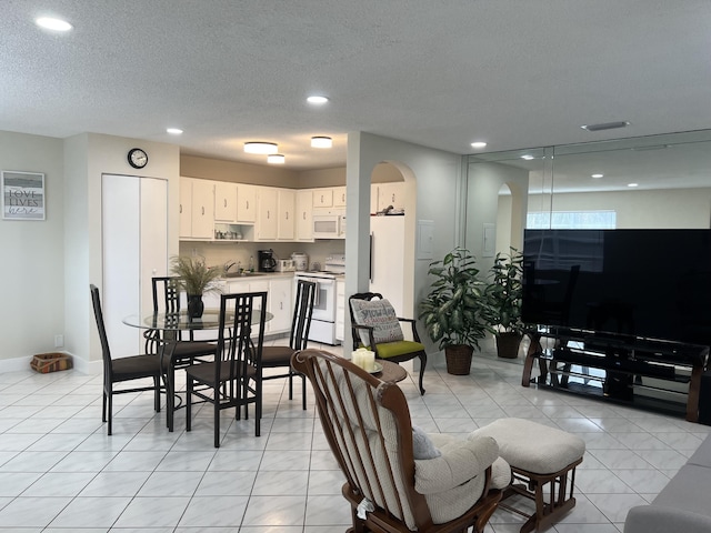 tiled living room featuring sink and a textured ceiling