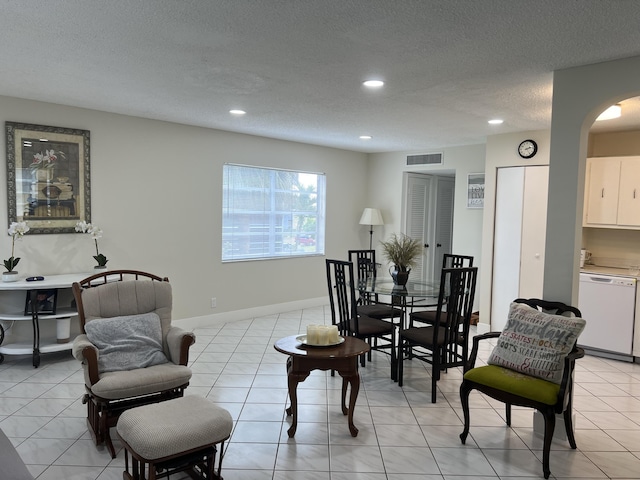 tiled living room featuring a textured ceiling