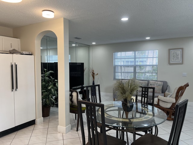 tiled dining area with a textured ceiling