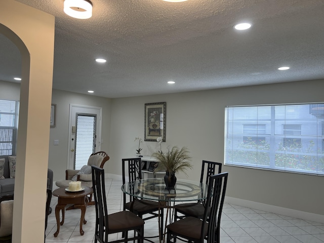 dining room with light tile patterned flooring and a textured ceiling