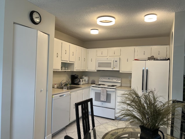 kitchen featuring white cabinetry, white appliances, sink, and light tile patterned floors