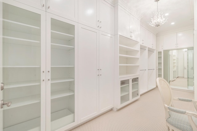 walk in closet featuring a chandelier and light carpet