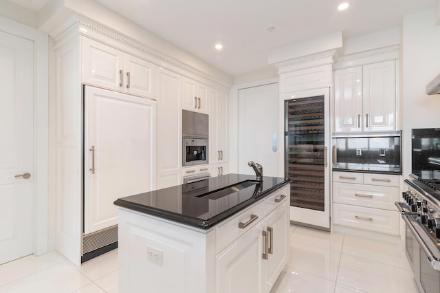 kitchen featuring wine cooler, light tile patterned floors, a kitchen island, and white cabinets