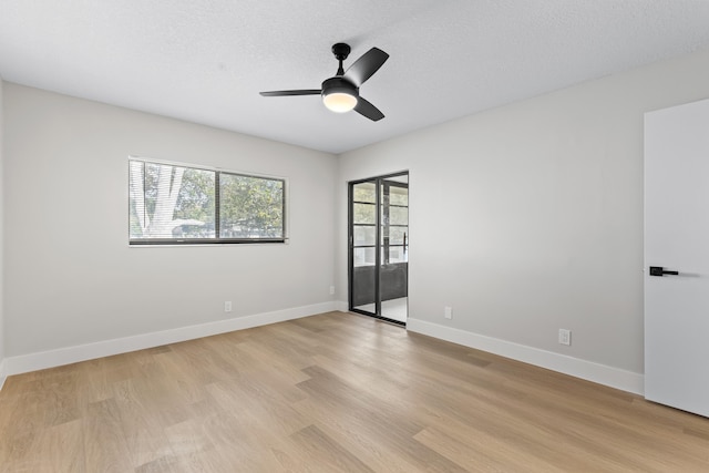 empty room with ceiling fan, light hardwood / wood-style floors, and a textured ceiling