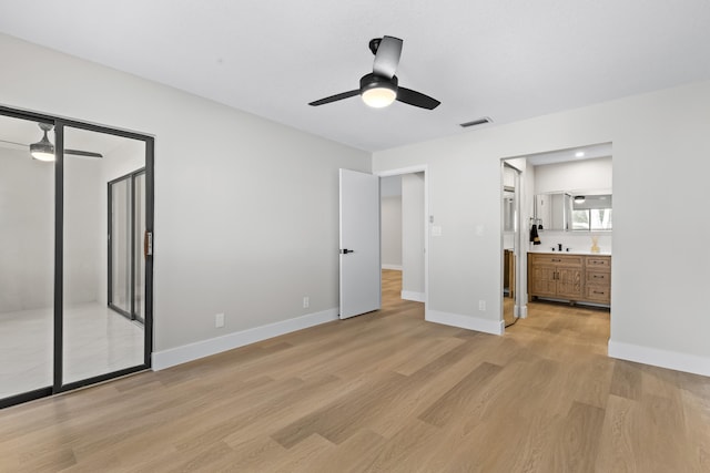 unfurnished bedroom with ceiling fan, connected bathroom, and light wood-type flooring