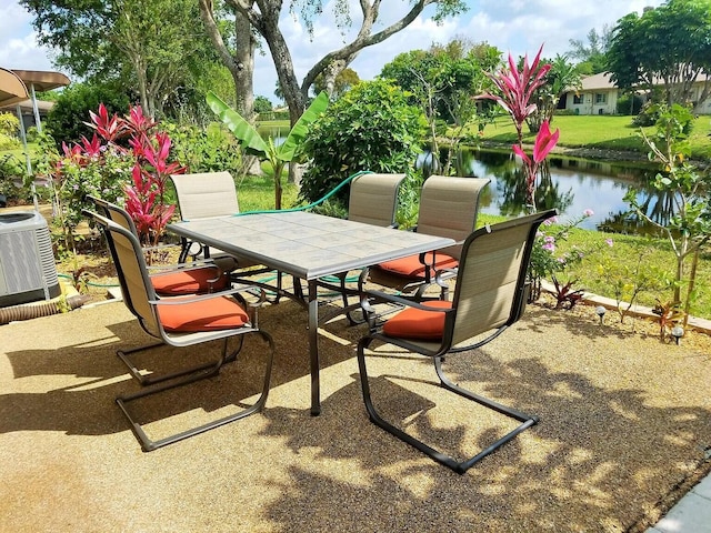 view of patio featuring outdoor dining area, a water view, and cooling unit