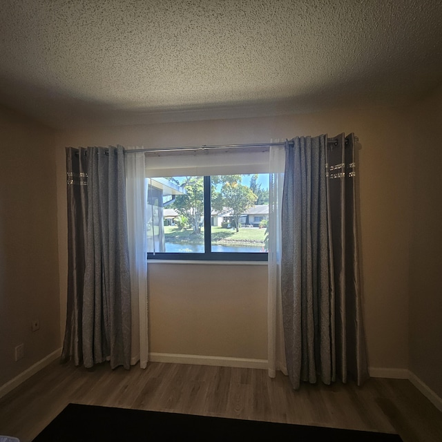 14640 Candy Way, Delray Beach, FL 33484 - empty room with wood finished floors, baseboards, and a textured ceiling