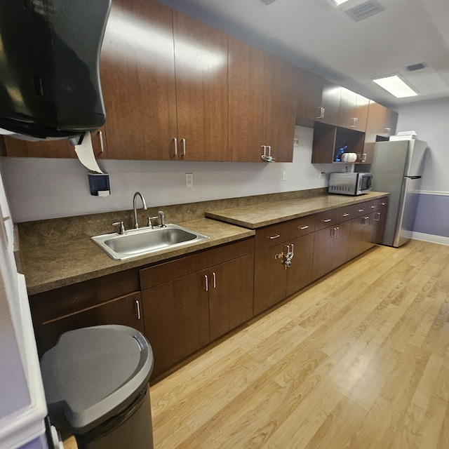 14640 Candy Way, Delray Beach, FL 33484 - kitchen with a sink, stainless steel appliances, light wood-type flooring, dark brown cabinetry, and exhaust hood