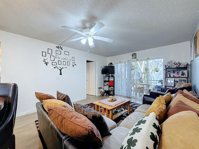 living room featuring ceiling fan, a textured ceiling, and light hardwood / wood-style floors