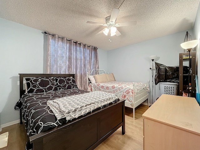 bedroom featuring ceiling fan, hardwood / wood-style floors, and a textured ceiling