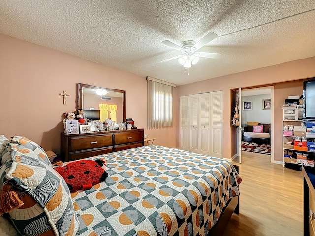 bedroom featuring ceiling fan, a textured ceiling, and light wood-type flooring