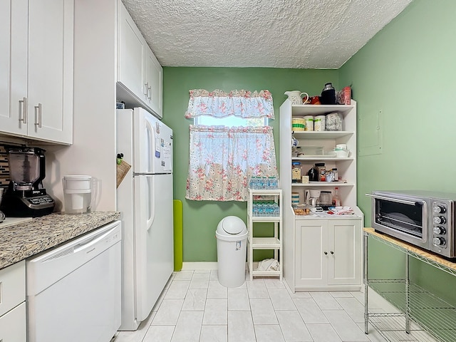 kitchen with white cabinetry, white appliances, light stone counters, and a textured ceiling