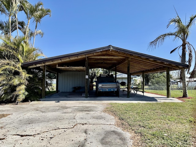 view of vehicle parking with a carport and a yard