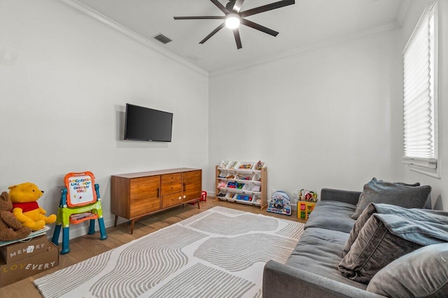 living room featuring crown molding, ceiling fan, and wood-type flooring