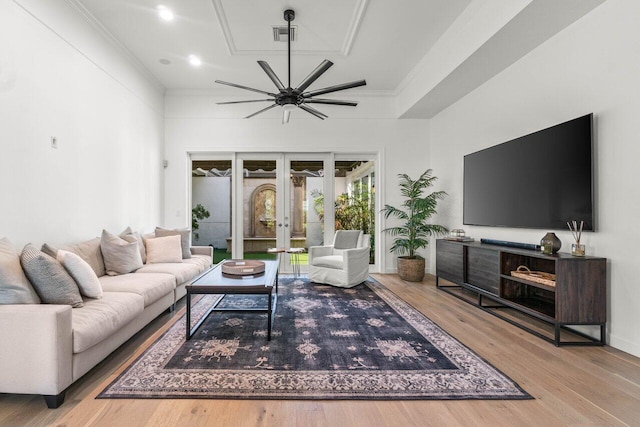 living room with hardwood / wood-style flooring, ornamental molding, and french doors