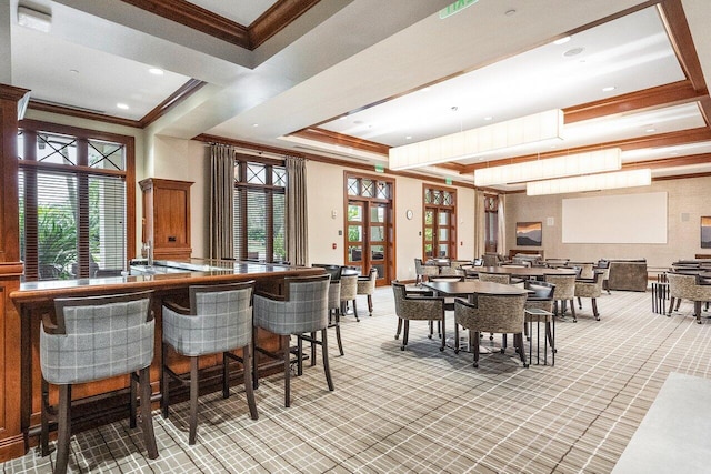 carpeted dining area with crown molding, a wealth of natural light, and a tray ceiling