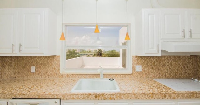 kitchen featuring tasteful backsplash, dishwasher, sink, and white cabinets