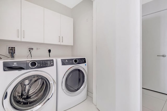 clothes washing area with cabinets and independent washer and dryer