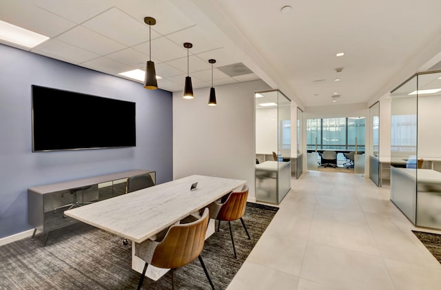 tiled dining room with a drop ceiling